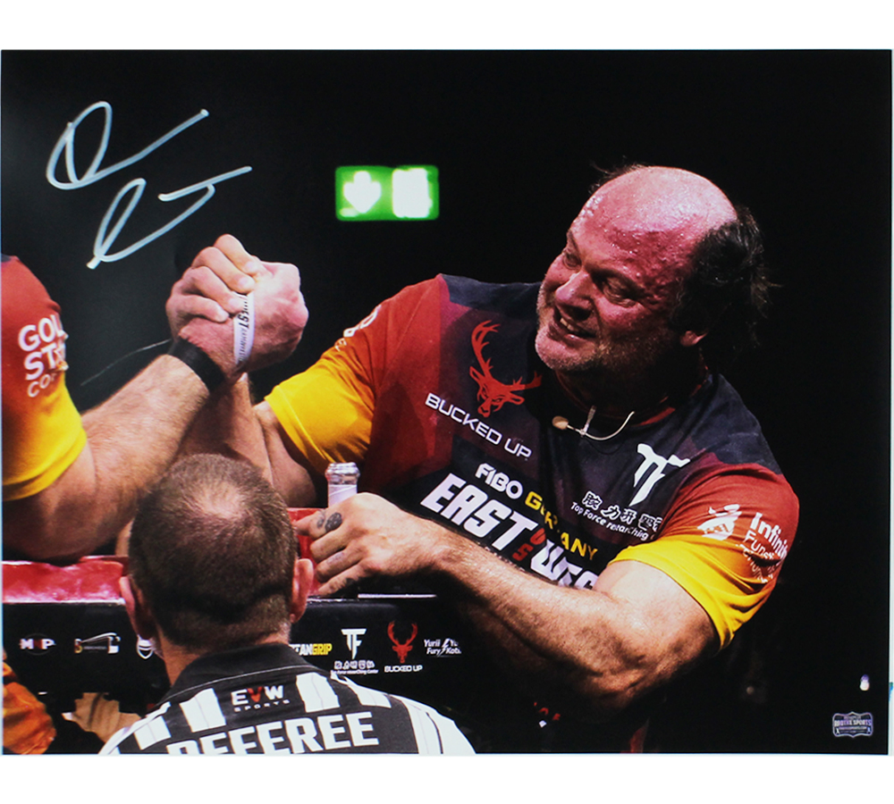Devon Larratt Signed Unframed 16x20 Arm Wrestling Photo - Black, Red and Yellow Shirt