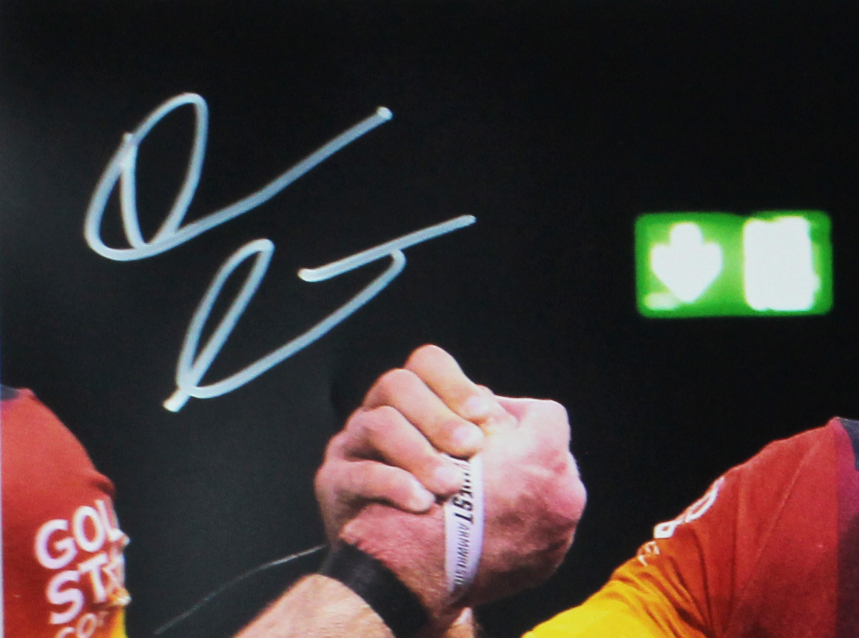 Devon Larratt Signed Unframed 16x20 Arm Wrestling Photo - Black, Red and Yellow Shirt - Image 2